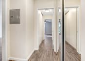 Thumbnail 20 of 23 - a renovated living room with a mirror and a hallway to a bathroom