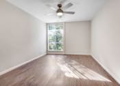 Thumbnail 16 of 23 - an empty living room with a ceiling fan and a window