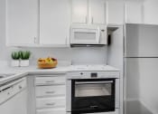 Thumbnail 7 of 61 - a white kitchen with an oven and a refrigerator