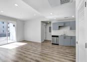 Thumbnail 27 of 42 - an empty living room with a kitchen and a balcony