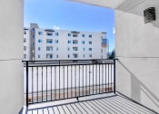 Thumbnail 8 of 42 - a balcony with a black railing and a white building in the background