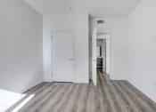 Thumbnail 38 of 42 - an empty living room with white walls and wood floors