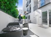 Thumbnail 18 of 42 - a patio with a table and chairs in front of a building