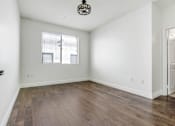 Thumbnail 51 of 88 - an empty living room with white walls and a window