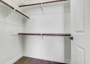 Thumbnail 54 of 88 - a walk in closet with white walls and a white closet door with a wood floor