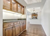 Thumbnail 58 of 88 - a kitchen with wooden cabinets and a hallway to a living room