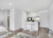Thumbnail 13 of 102 - a white living room with a kitchen and a couch