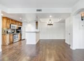 Thumbnail 59 of 88 - the living room and kitchen of a new home with wood floors and white walls