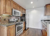 Thumbnail 25 of 88 - a kitchen with wooden cabinets and stainless steel appliances