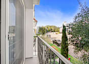 Thumbnail 60 of 88 - a balcony with a view of a street and a building with a glass door