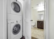 Thumbnail 65 of 88 - a white washer and dryer in a bathroom with a toilet and a sink