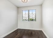 Thumbnail 63 of 88 - an empty living room with a window and hardwood floors