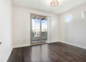 Thumbnail 62 of 88 - an empty living room with a sliding glass door to a balcony