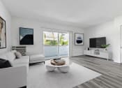 Thumbnail 4 of 23 - a living room with a white couch and a coffee table