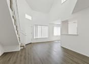 Thumbnail 25 of 94 - an empty living room with white walls and wood floors