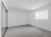 Thumbnail 28 of 94 - the spacious living room of an apartment with white walls and a window