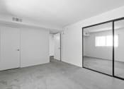 Thumbnail 29 of 94 - an empty living room with a large mirror and white walls