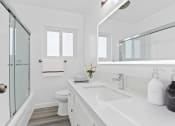 Thumbnail 7 of 23 - a white bathroom with a sink and a shower