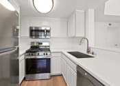 Thumbnail 12 of 94 - a renovated kitchen with white cabinets and stainless steel appliances