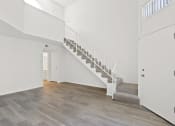 Thumbnail 26 of 94 - a white room with a staircase and a door to a hallway and a white door