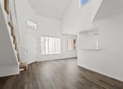 Thumbnail 16 of 94 - the living room and entryway of a house with white walls and wood floors