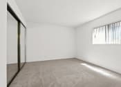 Thumbnail 18 of 94 - the spacious living room of an apartment with white walls and a window