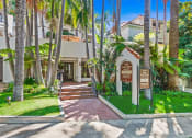 Thumbnail 4 of 10 - a house with palm trees and a sign in front of it