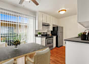 Thumbnail 2 of 22 - a kitchen and dining area with a large window and stainless steel appliances