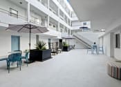 Thumbnail 39 of 45 - a large room with tables and chairs and umbrellas in an office building