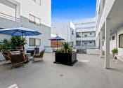 Thumbnail 33 of 45 - an outdoor patio with tables and chairs and umbrellas at a building