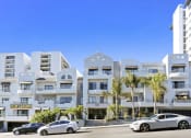 Thumbnail 29 of 45 - an apartment building with palm trees and cars parked in front of it