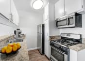 Thumbnail 10 of 64 - a kitchen with stainless steel appliances and a counter top with oranges