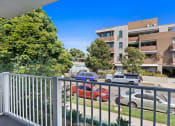 Thumbnail 7 of 32 - the view from the balcony of an apartment building with cars parked on the street