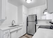 Thumbnail 17 of 73 - a kitchen with white cabinets and a stainless steel refrigerator