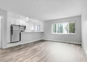 Thumbnail 12 of 73 - the living room and kitchen of an empty apartment with wood flooring and a window