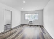 Thumbnail 4 of 73 - a living room with white walls and wooden floors and a window