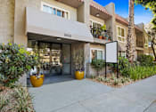 Thumbnail 21 of 24 - the sidewalk in front of a building with a patio and potted plants