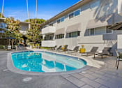 Thumbnail 19 of 24 - a swimming pool in front of a building with chairs and a resort style pool