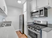 Thumbnail 21 of 64 - a kitchen with stainless steel appliances and white cabinets
