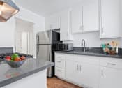 Thumbnail 2 of 34 - a kitchen with white cabinets and a stainless steel refrigerator