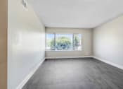 Thumbnail 35 of 64 - an empty living room with a window and wood floors