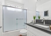 Thumbnail 9 of 34 - a bathroom with a shower and a sink and a toilet