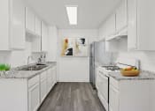 Thumbnail 1 of 8 - a white kitchen with marble counter tops and stainless steel appliances