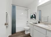 Thumbnail 7 of 8 - a bathroom with a shower toilet and sink and a mirror