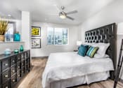 Thumbnail 5 of 35 - A bedroom with a large bed and a black headboard.