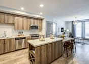 Thumbnail 8 of 35 - A modern kitchen with wooden cabinets and a central island.