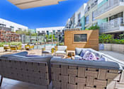 Thumbnail 33 of 40 - A modern outdoor seating area with a large couch and a small wooden structure.