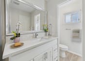 Thumbnail 33 of 79 - A bathroom with a white countertop and a white toilet.