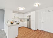Thumbnail 14 of 40 - a kitchen with white cabinetry and a wooden floor