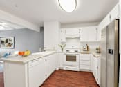 Thumbnail 5 of 40 - a kitchen with white cabinets and a wooden floor